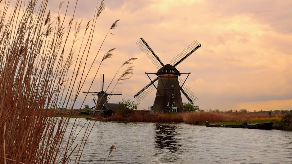 Picturesque view of historic windmills in Kinderdijk, Netherlands during a stunning sunset.